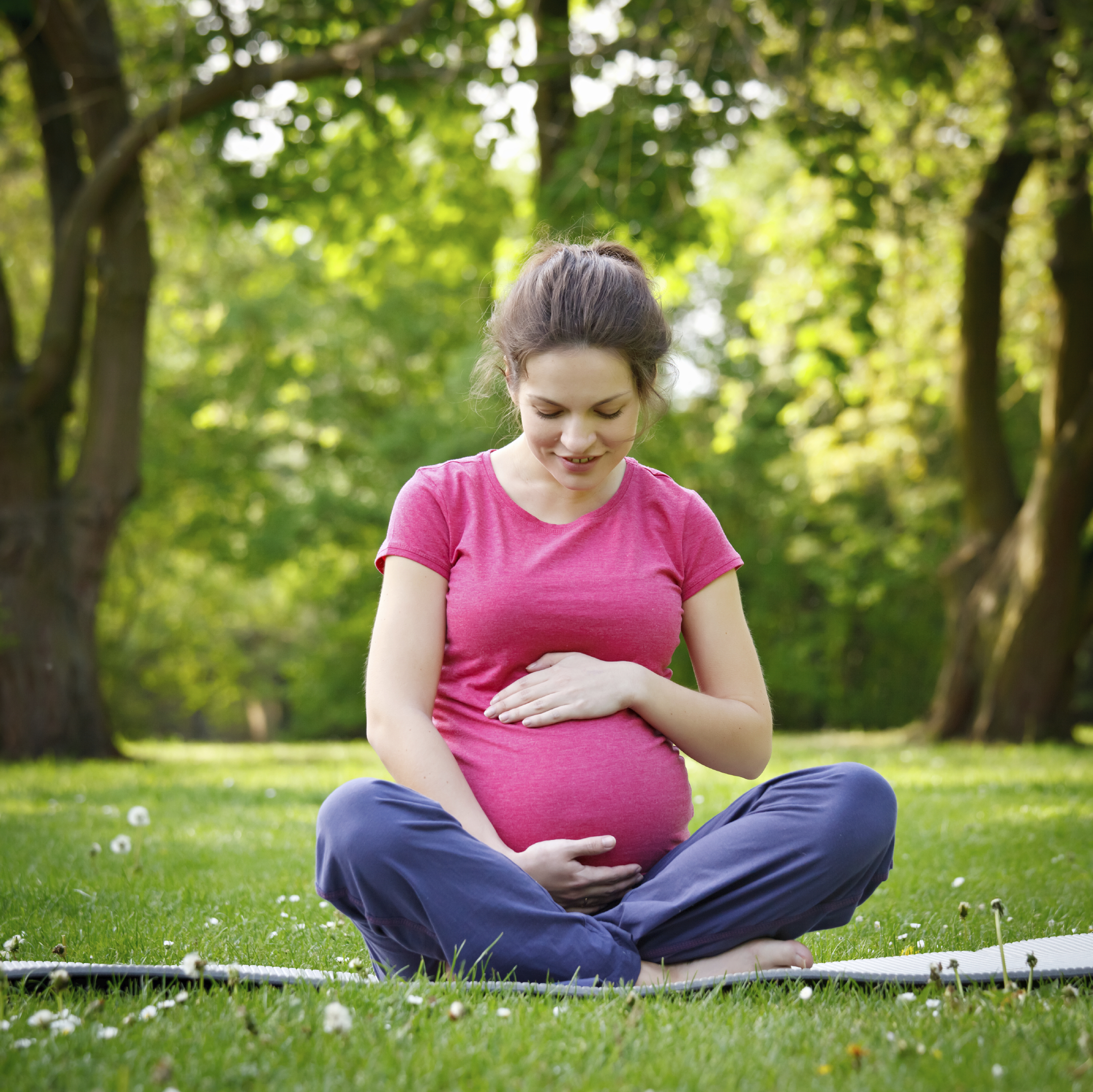 Beautiful pregnant woman relaxing in the park
