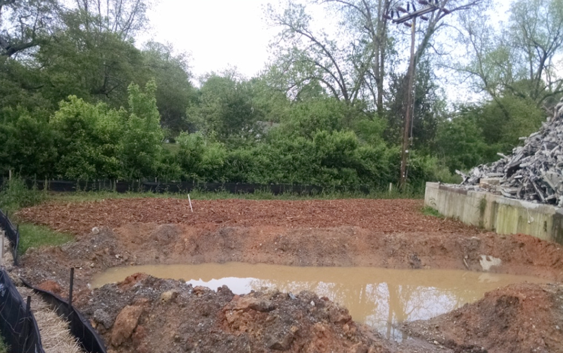 Figure 5. Soil excavated in the area where flooding occurred from the ruptured water main. Mill Creek runs parallel to, and just the other side of, the overgrown fence in the background.