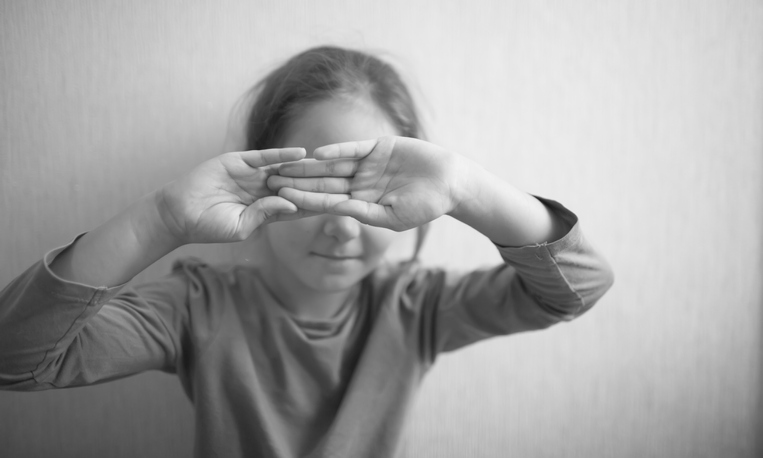 A little girl protects herself with her palm