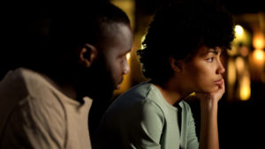 Stressed couple sitting outside, not talking