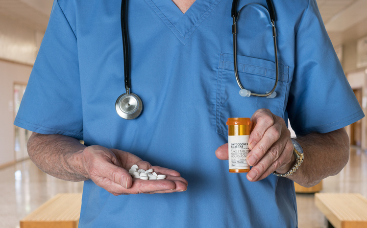 Generic oxycodone tablets in hands of doctor