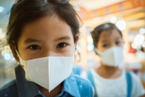 Cute asian child girl wearing protection mask to against air pollution
