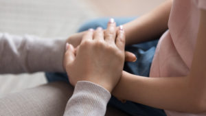 Mom giving support trust to little daughter holding hands, closeup