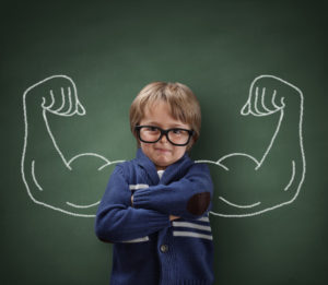Strong man arms showing bicep muscles behind a boy in glasses
