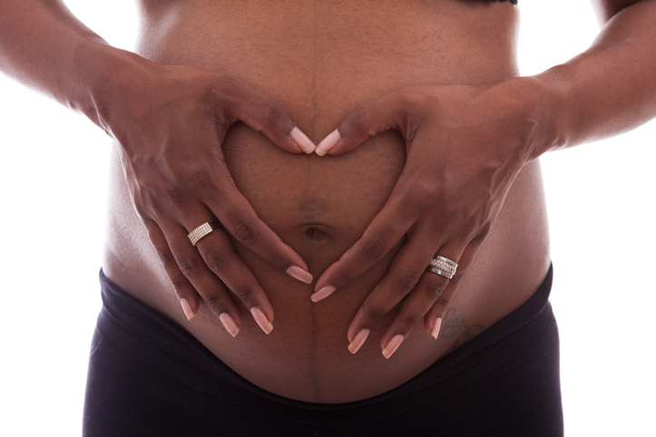 Young beautiful pregnant African-American woman touching her belly