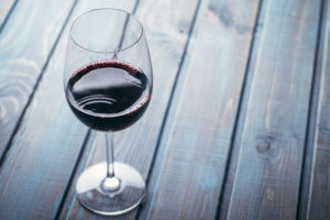Glass of red wine on a blue wooden table at a bar