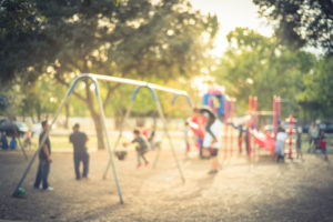 Blurred motion kids swing back and forth at public playground in USA