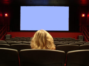 A Girl sits Alone in a Movie Theater