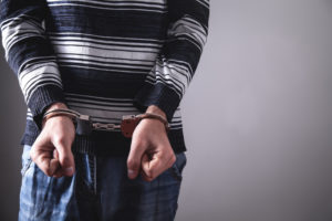 Young man in handcuffs. 