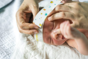 Measuring the head circumference of a newborn baby boy in the hospital