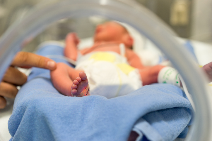 Premature baby in NICU with hand of the doctor