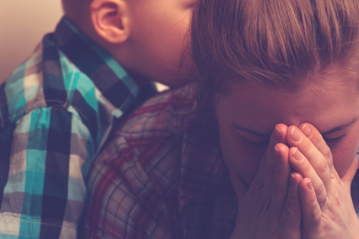 Crying stressed-out mother with child at home