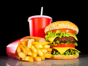 Standard American Diet: hamburger and french fries on a dark background