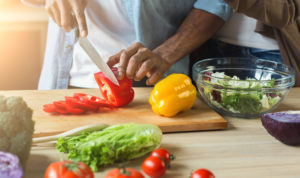 cutting vegetables for healthy vegetarian salad in kitchen