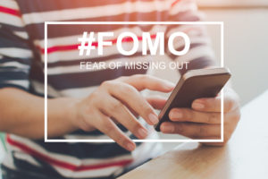 FOMO, fear of missing out concept. Close-up image of male hands using mobile smartphone