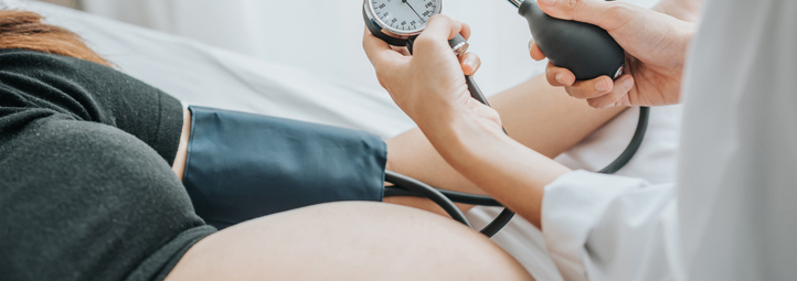 Doctor checking blood pressure of a pregnant woman